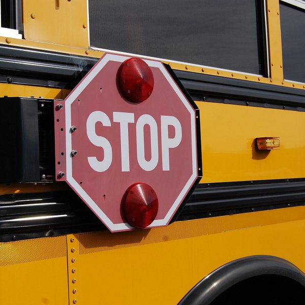 A yellow school bus with a red stop sign