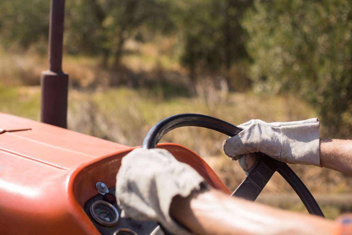 Close up of gloved hands on a tractor steering wheel