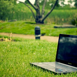 A laptop sitting outside in the grass